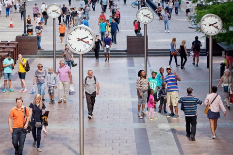 People in a square with clocks
