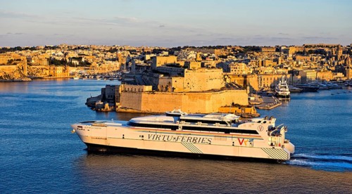 Jean de la Valette ferry of the Virtu Ferries shipping company passing the fortress Fort St. Angelo in the Grand Harbour