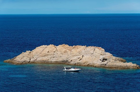 Motorboat in front of rock