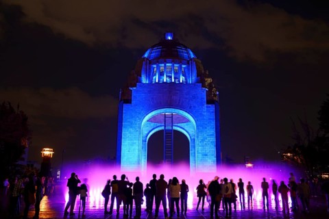 People watching the light show and fountains in front of the Monument to the Revolution