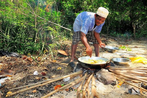 Man at cooking fire on the beach of Ilots Choizil