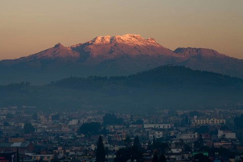 The volcano Iztaccihuatl in early morning light with city
