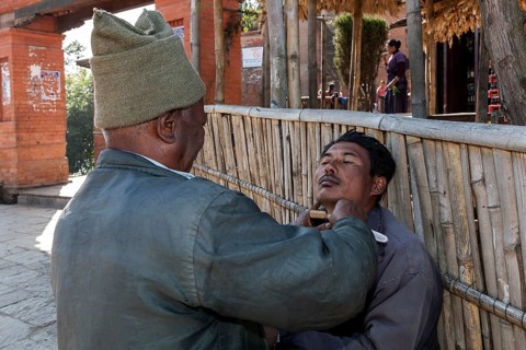 Man being shaved by a barber in Nargakot