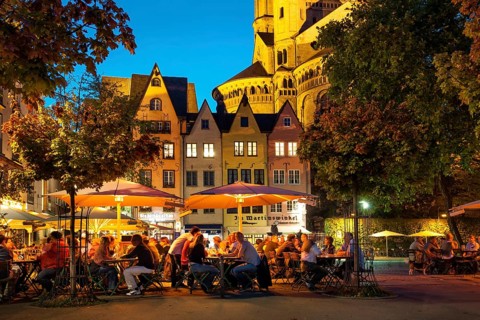 Outdoor cafes in Fischmarkt square with Great St. Martin Church in the evening