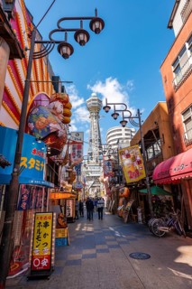 Many colorful advertising signs in a pedestrian zone with shops and restaurants