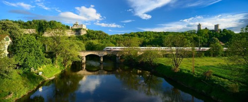 Ruins of Rudelsburg Castle and Burg Saaleck Castle on the Saale River with an ICE train crossing a railway bridge
