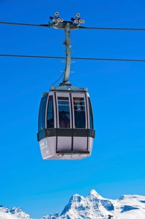 Gondola of the Moosfluh cable car in front of the snowy mountain range of the Valais Alps