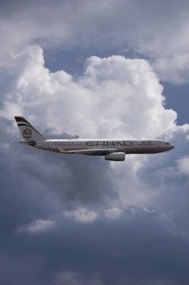A6-EYK Etihad Airways Airbus A330-243 in flight against a cloudy sky