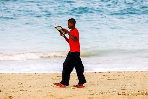 School boy walking along the beach