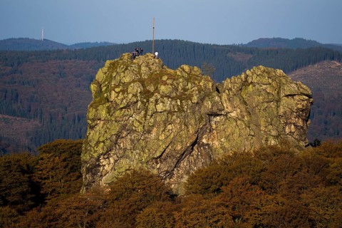 Bruchhauser Steine rocks with a group of visitors at the summit cross