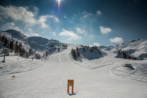 Ski slope with signposts and a few skiers on Gamskogel