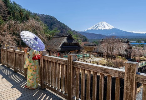 Japanese woman in kimono with paper umbrella in the open-air museum Iyashinosato