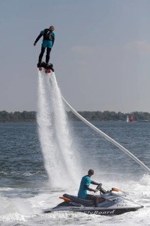 Flyboarder on the water jet of a jet ski