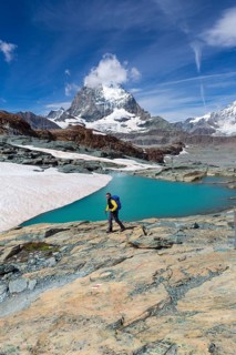 Hiker at glacier lake on the way to the Gandegg hut