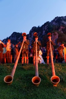 Alphorn players in the glow of bonfires