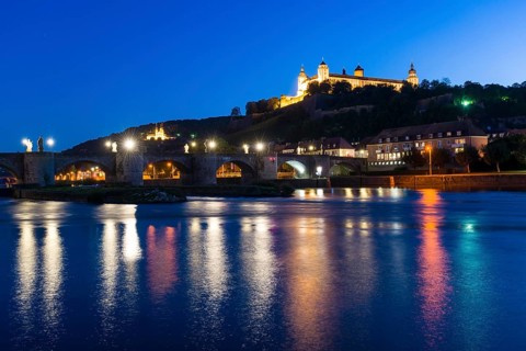 The illuminated Festung Marienberg castle located on a hill above the town
