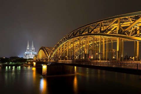 The illuminated Cologne Cathedral and Hohenzollern Bridge at night with Rhine