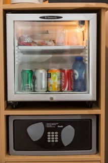 Mini bar with drinks and a safe for valuables in a hotel room
