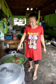 Young woman cooking in a simple restaurant
