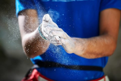 Climber coating his hands with magnesium