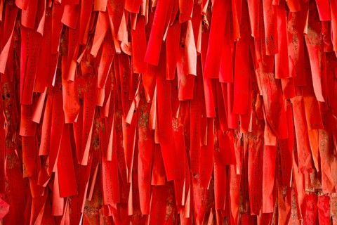 Red luck or wishing papers on a wall in the temple
