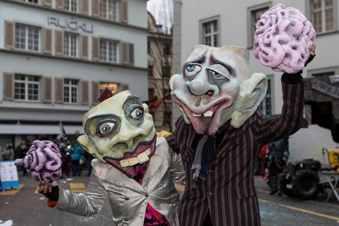 Pair wearing masks holding a brain