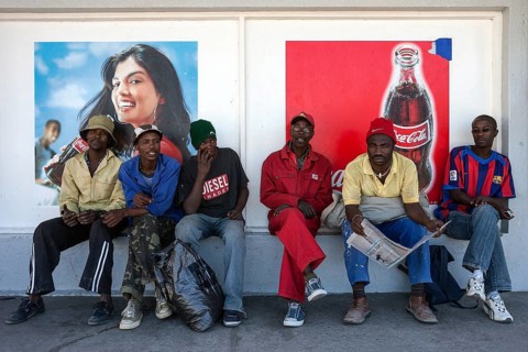 Namibian men sitting in front of advertising posters