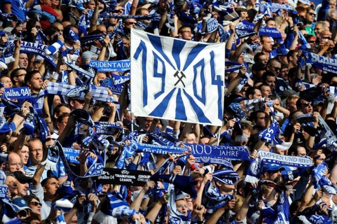 Schalke fans on the north stand holding up scarves and a banner ""1904""