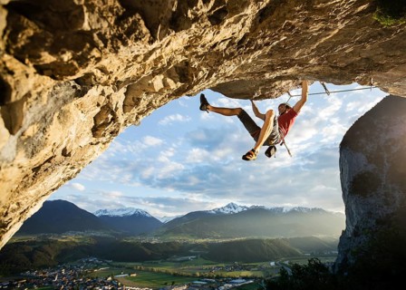 Freeclimber with helmet climbing on a rock face