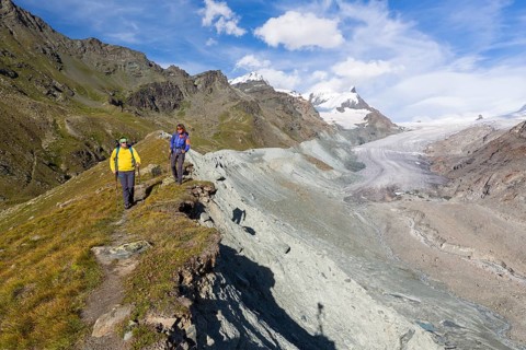 A man and a woman hiking on the moraine of the Findel Glacier at Fluhalp