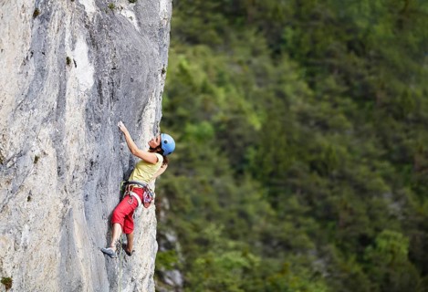 Freeclimber with helmet climbing on a rock face