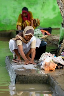 Woman washing laundry by the river