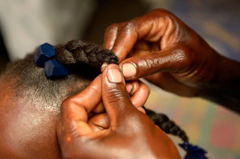 Mother braiding her daughter's hair