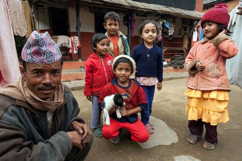 Nepalese father and children in front of their house