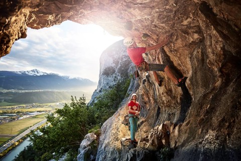 Freeclimber with helmet climbing on a rock face