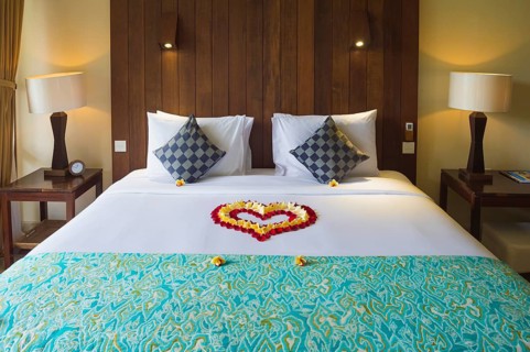 Hotel bed decorated with flower petals