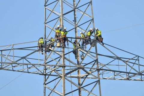 Overhead linemen working on a pylon