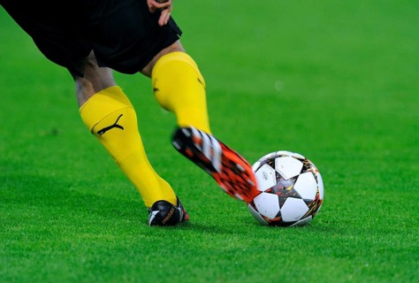 Legs of a BVB player with adidas Champions League Ball