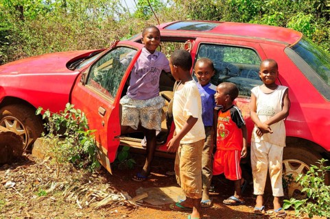 Happy children playing at a car wreck
