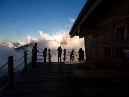 Climbers on the patio of Mantova Hut at sunset