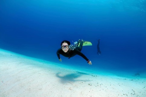 Freediver above sandy bottom