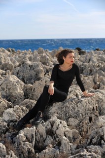 Teenager sitting on rocks by the sea