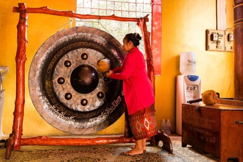 Monk using a Gong during the prayer
