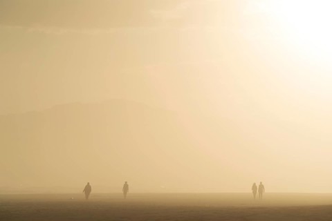 People walking at the beach at sunset