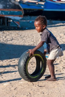 Malagasy child playing with a used tire