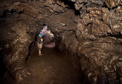 Tourist standing in a subterranean lava tube created by an eruption of the Piton de la Fournaise volcano