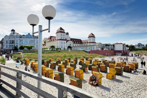 Roofed wicker beach chairs in front of the Kurhaus spa building