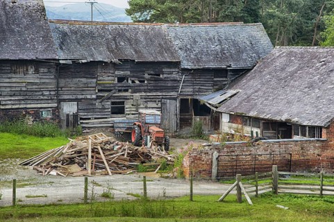 Derelict farmyard with old farm buildings and tractor