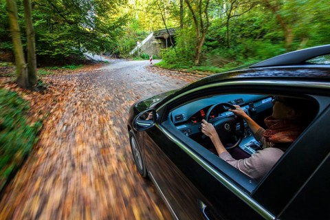 Car driving on a street covered with leaves