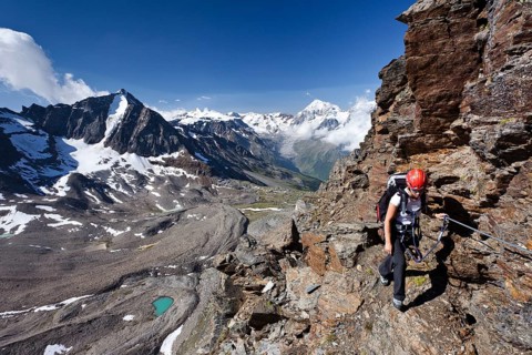 Hiker climbing the Croda di Cengles mountain on the fixed rope route above the Duesseldorfhuette mountain hut in Sulden